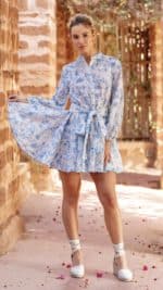 Robe courte en coton brodé blanc et bleu d'une marque parisienne, avec imprimé floral, manches longues et ceinture à nouer